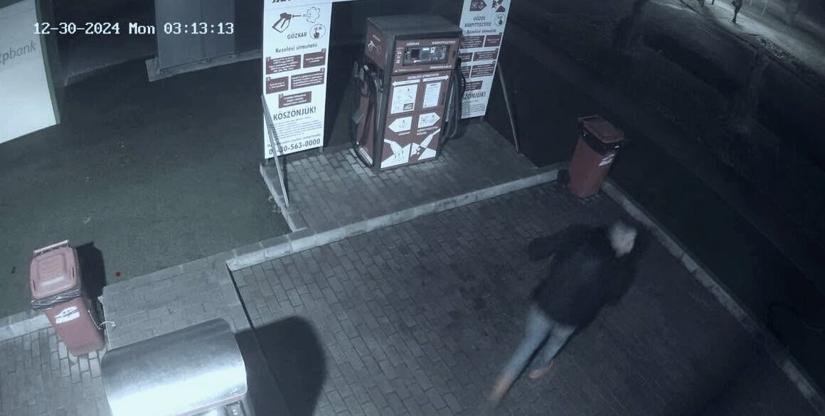 A telephely hajnalban: a megvilágított gépsor, egy vendég a mosóautomatánál, a felvétel sarkában a 03:13-as időbélyeg.